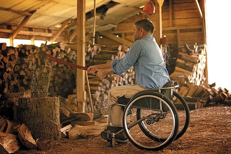 Man in wheelchair chopping wood