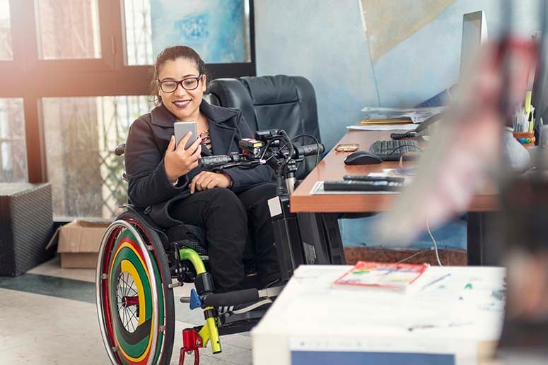 Woman in wheelchair in her office